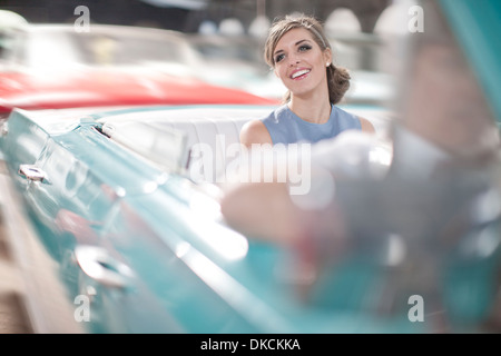 Woman enjoying ride in back seat of vintage convertible Banque D'Images