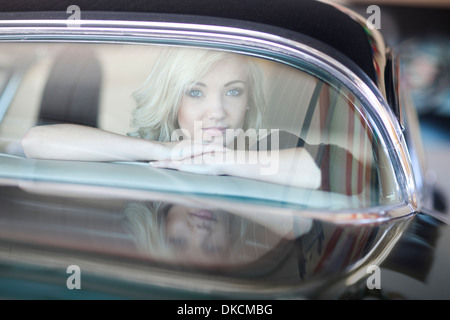 Femme à l'arrière pare-brise de voiture Banque D'Images