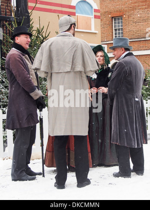 Acteurs en costumes victoriens debout dans la neige Banque D'Images