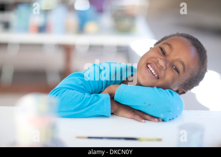 Happy girl les bras croisés sur la table Banque D'Images