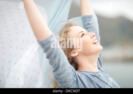 Woman stretching avec foulard en main, Hout Bay, Cape Town, Afrique du Sud Banque D'Images