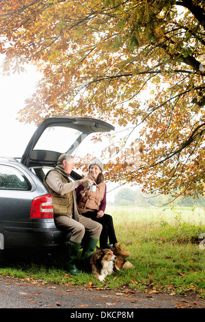Couple avec des chiens de café partage car boot, Norfolk, UK Banque D'Images