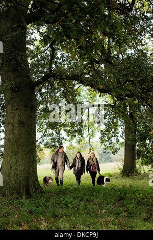 Couple et petite-fille de marcher le chien, Norfolk, UK Banque D'Images