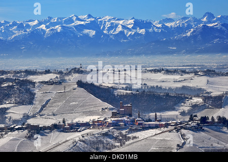 Typique de la petite ville italienne sur les collines couvertes de neige et des pics de montagne sur contexte en Piémont, Italie du Nord. Banque D'Images