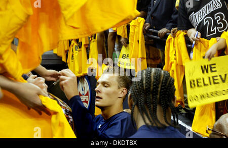 Golden State Warriors' Andris Biedrins, centre, signes memorabila de fans avant le troisième match contre les Dallas Mavericks à l'Oracle Arena à Oakland, Californie, le vendredi 27 avril 2007. (Ray Chavez/l'Oakland Tribune) Banque D'Images
