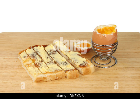 Toasts et des soldats sur une planche en bois sur un fond blanc. Banque D'Images