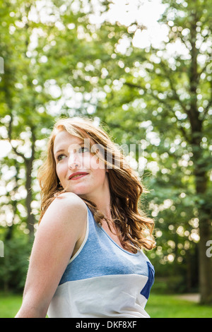 Young woman sitting in park Banque D'Images