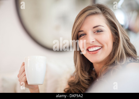 Portrait of young woman holding coffee mug Banque D'Images