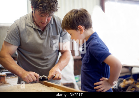 Père Fils montrant en menuiserie atelier bateau Banque D'Images