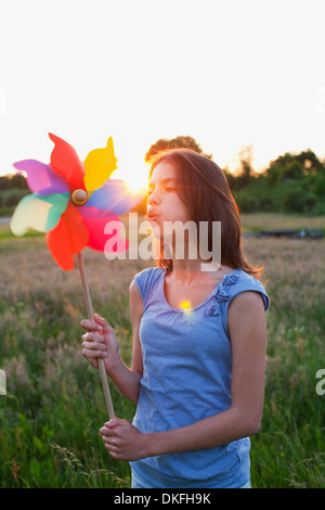 Girl blowing toy moulin Banque D'Images