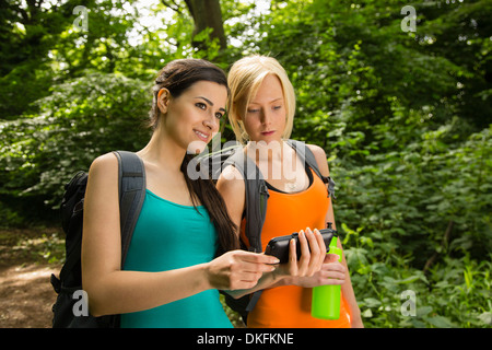 Femmes sur la marche en forêt, à la recherche de GPS au Banque D'Images