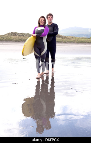 Portrait de couple avec surfboard on beach Banque D'Images