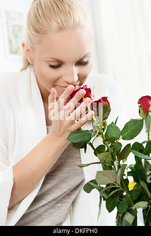 Young blonde woman smelling bouquet de roses à Banque D'Images