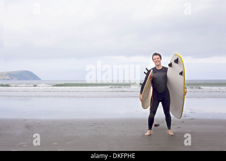 Portrait d'homme avec des planches sur la plage Banque D'Images