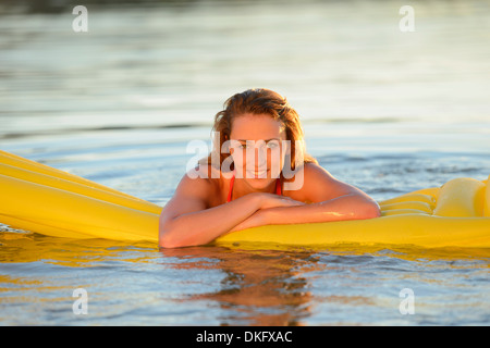 Jeune femme avec des matelas dans un lac Banque D'Images