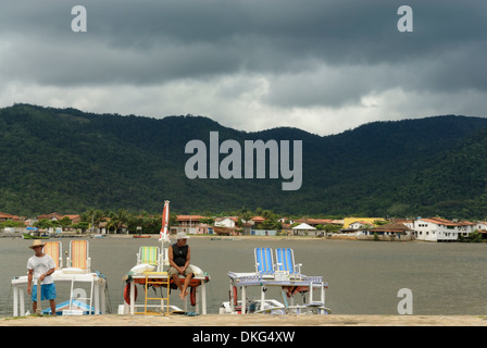 Batelier de la brésilienne locale petit port en attente à leurs bateaux pour les touristes ; Paraty, Espirito Santo, au Brésil. Banque D'Images