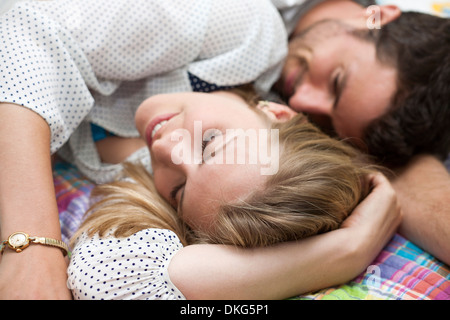 Close up of couple relaxing on bed Banque D'Images