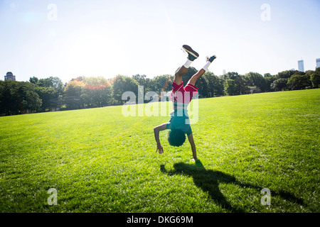 Jeune homme faisant la roue en position de stationnement Banque D'Images