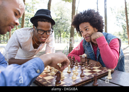 Trois jeunes hommes jouant aux échecs dans le parc Banque D'Images
