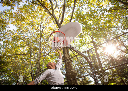 Jeune homme but de basket-ball de notation Banque D'Images