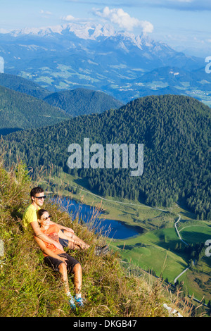 Young couple lying in mountain meadow dans le groupe Osterhorn, Salzburg, Autriche Etat Banque D'Images