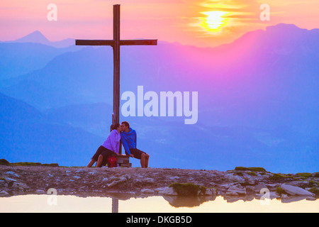 Couple au coucher du soleil au sommet cross dans le groupe Osterhorn, Salzburg, Autriche Etat Banque D'Images