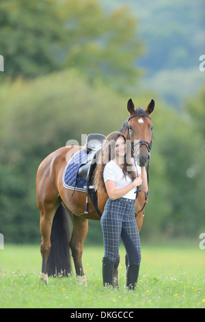 Teenage Girl standing avec un cheval sur un paddock Broderstorf Banque D'Images