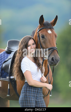 Teenage Girl standing avec un cheval sur un paddock Broderstorf Banque D'Images