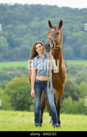 Teenage Girl standing avec un cheval sur un paddock Broderstorf Banque D'Images
