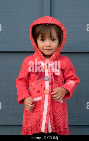 Un enfant de deux ans M. mixed race female sourit tout en ayant sa photo prise. Elle a les cheveux bruns, les yeux bruns Banque D'Images