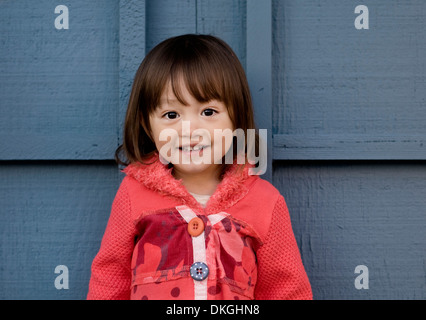 Un enfant de deux ans M. mixed race female sourit tout en ayant sa photo prise. Elle a les cheveux bruns, les yeux bruns Banque D'Images