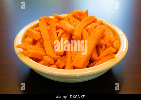 Sweet Potato Spears cuit avec du beurre et de la cassonade pour le dîner de Thanksgiving à Bol sur l'arrière-plan de table Banque D'Images