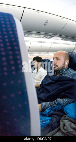 Confortable 2 Boeing 787 Dreamliner passagers bénéficient de personnels audio video TV sur demande dans l'économie de l'intérieur de la cabine pendant le vol. Banque D'Images