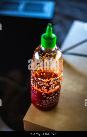 Une bouteille de partiellement utilisés Sriracha sauce chili Banque D'Images