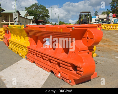 L'orange vif et jaune en plastique portable barrière de sécurité à un site de construction Banque D'Images