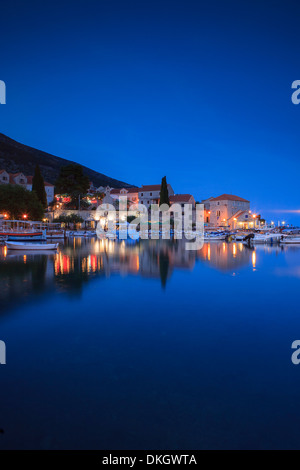 Le port de Bol illuminée au crépuscule, Bol, Île de Brac, la côte dalmate, en Croatie, en Europe Banque D'Images