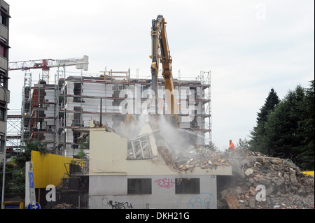 Une perforatrice pneumatique démolition d'une maison avec à l'arrière une nouvelle construction Banque D'Images