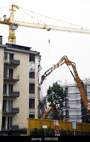 Une perforatrice pneumatique démolition d'une maison avec à l'arrière une nouvelle construction Banque D'Images