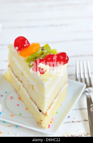 Morceau de gâteau délicieux sur fond blanc Banque D'Images