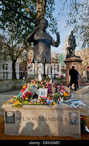 Londres, Royaume-Uni. 6e décembre 2013. Les membres du public allumer des bougies, déposer des fleurs, couronnes, photographies, cartes et drapeaux de l'Afrique du Sud à la base de la statue de Nelson Mandela dans le quartier à la place du Parlement en hommage au regretté chef. Credit : Pete Maclaine/Alamy Live News Banque D'Images