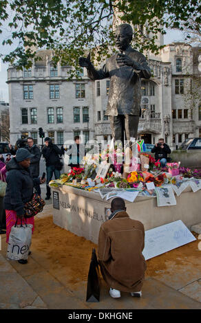 Londres, Royaume-Uni. 6e décembre 2013. Les membres du public allumer des bougies, déposer des fleurs, couronnes, photographies, cartes et drapeaux de l'Afrique du Sud à la base de la statue de Nelson Mandela dans le quartier à la place du Parlement en hommage au regretté chef. Credit : Pete Maclaine/Alamy Live News Banque D'Images