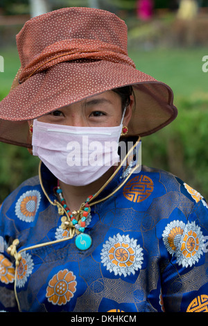 Portrait de femme portant un masque tibétain de la pollution, Lhassa, Tibet, Chine Banque D'Images