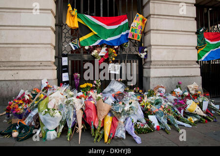 Londres, Royaume-Uni. 6e dec 2013.Les membres de la fonction allumer des bougies, déposer des fleurs, couronnes, photographies, cartes et drapeaux de l'Afrique du Sud à la porte de la maison de l'Afrique du Sud en hommage à la fin de file. Credit : Pete Maclaine/Alamy Live News Banque D'Images