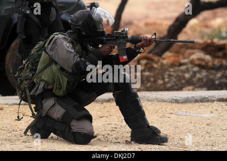 Ramallah, Cisjordanie, territoire palestinien, . 6e déc, 2013. Un soldat israélien rubbers vers les manifestants palestiniens au cours d'affrontements à la suite d'une manifestation hebdomadaire contre l'occupation israélienne dans le village cisjordanien de Bil'in le 6 décembre 2013. Le secrétaire d'Etat américain John Kerry a exhorté les dirigeants israéliens et palestiniens à s'inspirer de Nelson Mandela dans les pourparlers de paix, comme il a conclu une autre visite dans la région Crédit : Issam Rimawi APA/Images/ZUMAPRESS.com/Alamy Live News Banque D'Images