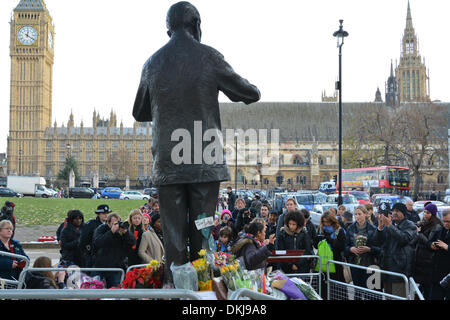 Londres, Royaume-Uni. 06 Dec, 2013. Congé de deuil, fleurs et messages au pied de la statue de Nelson Mandela à la place du Parlement, Londres. Nelson Mandela, premier président noir d'Afrique du Sud est mort le 5 décembre 2013 après une longue lutte avec sa santé. Credit : Patricia Phillips/Alamy Live News Banque D'Images