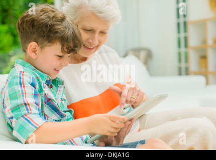 Femme plus âgée et petit-fils using digital tablet Banque D'Images