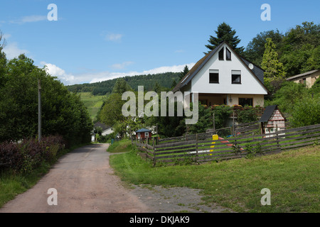 Petite route de maisons en pays de collines Banque D'Images