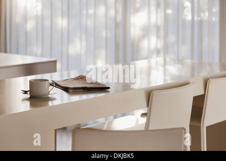 Café et journal sur un comptoir à petit-déjeuner dans une cuisine moderne Banque D'Images