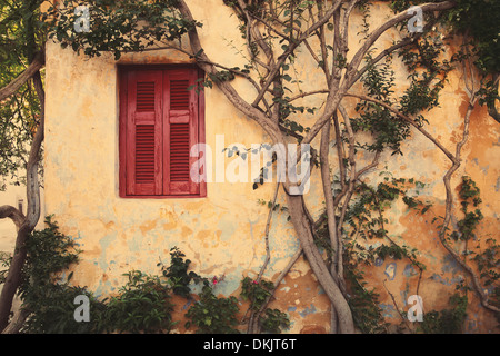 Fenêtre avec volet d'Anafiotika rouge dans la ville d'Athènes, Grèce.Vintage style. Banque D'Images