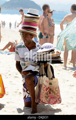 Une plage hawker avec sa tête de chapeaux pour les ventes a attiré un groupe de touristes sur la plage de Copacabana, Rio de Janeiro, Brésil. Banque D'Images